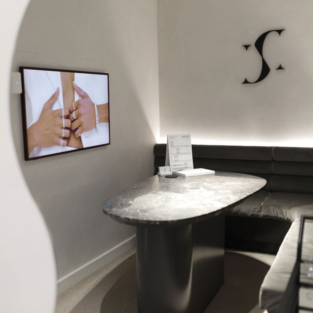 Modern interior with a sleek black table and gray walls featuring a television screen.