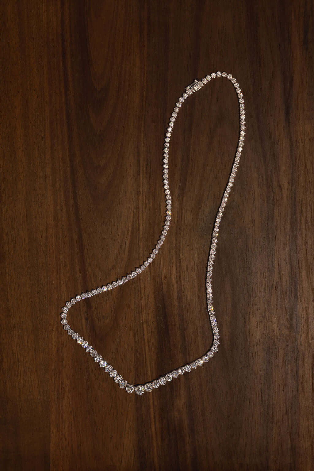 Graduated Riviera Diamond Necklace 14.6ct Lab Diamond displayed on dark wooden surface.
