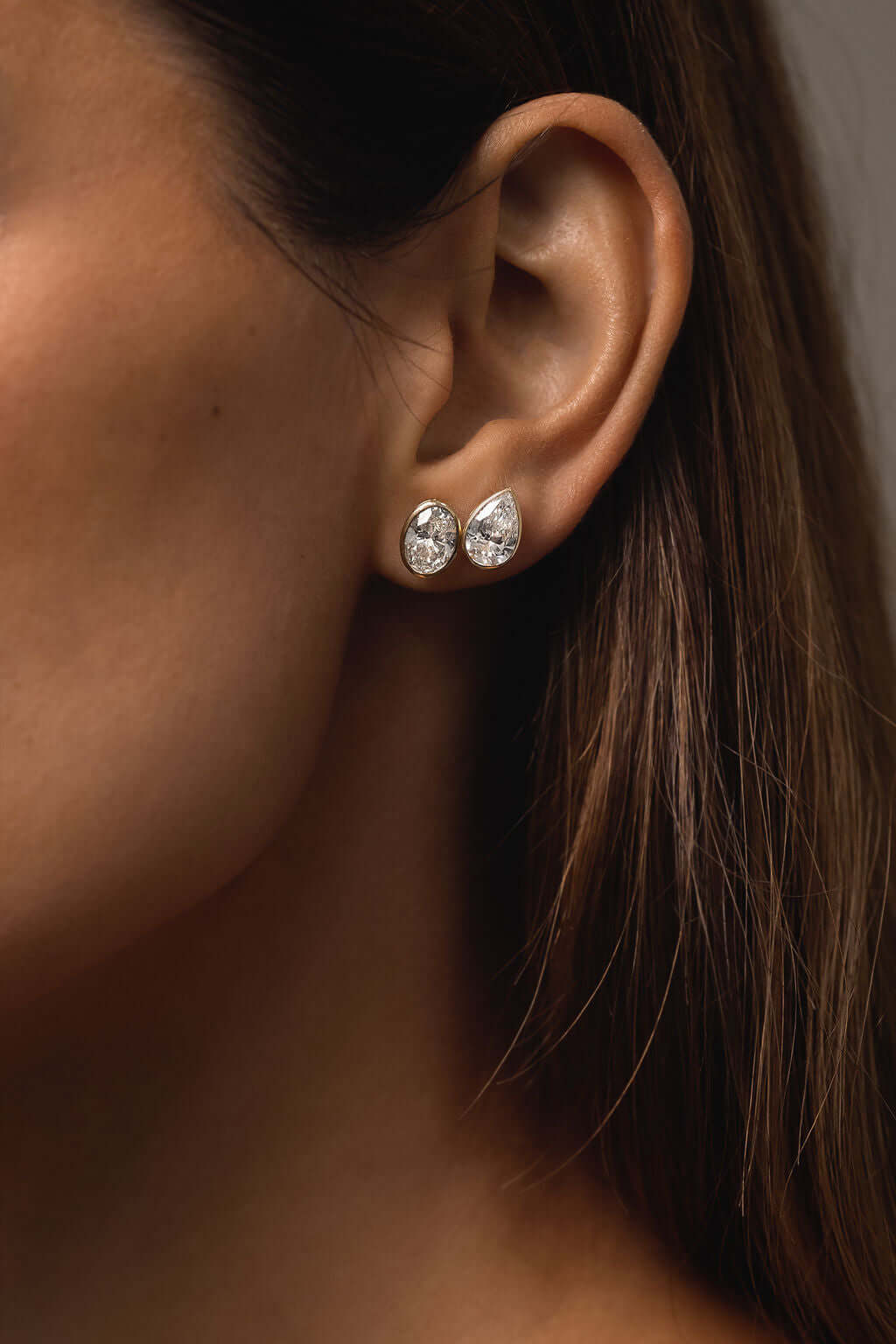 Oval Bezel Stud Earrings Lab Diamond in 9ct white gold featuring lab diamonds worn by a model.