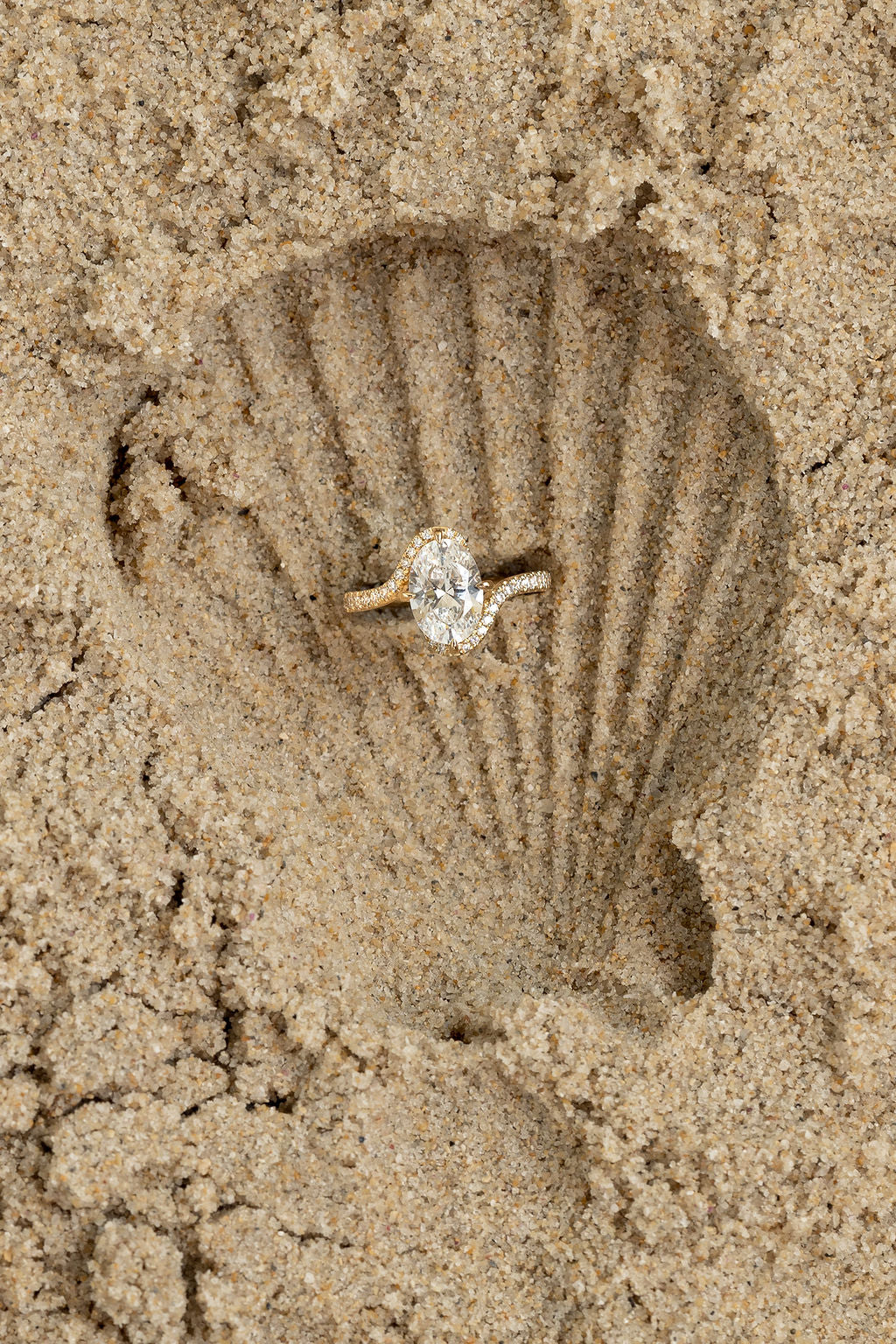 Diamond ring on a shell impression in sand