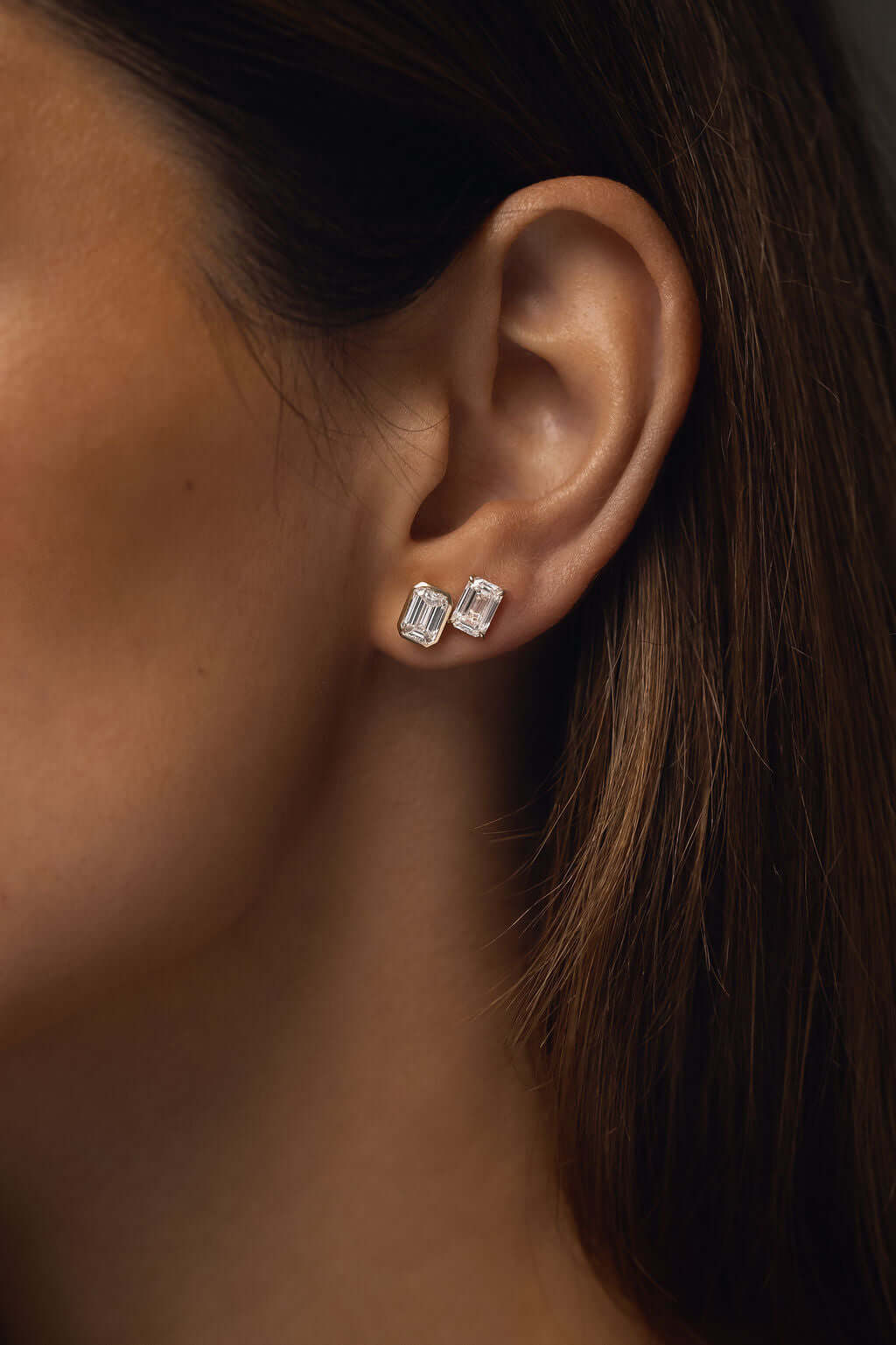 Emerald Bezel Stud Earrings Lab Diamond shown on model, highlighting their elegance and sparkle in pristine detail.