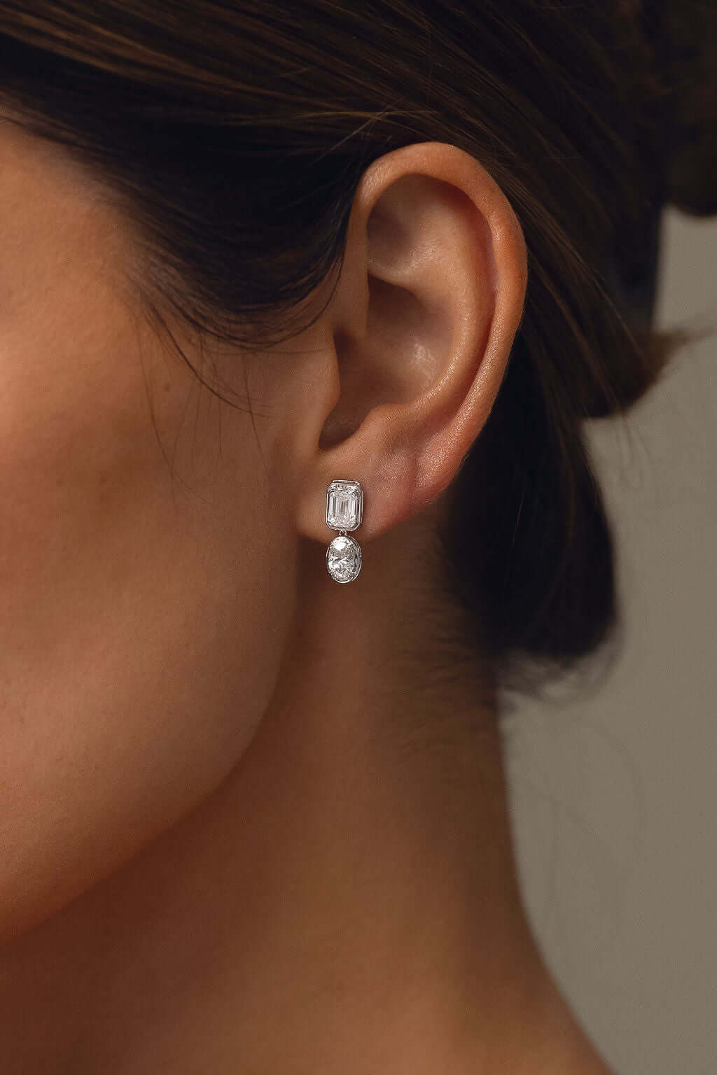 Emerald and Oval Bezel Stud Earrings Lab Diamond worn by model showcasing elegance in 9ct white gold.