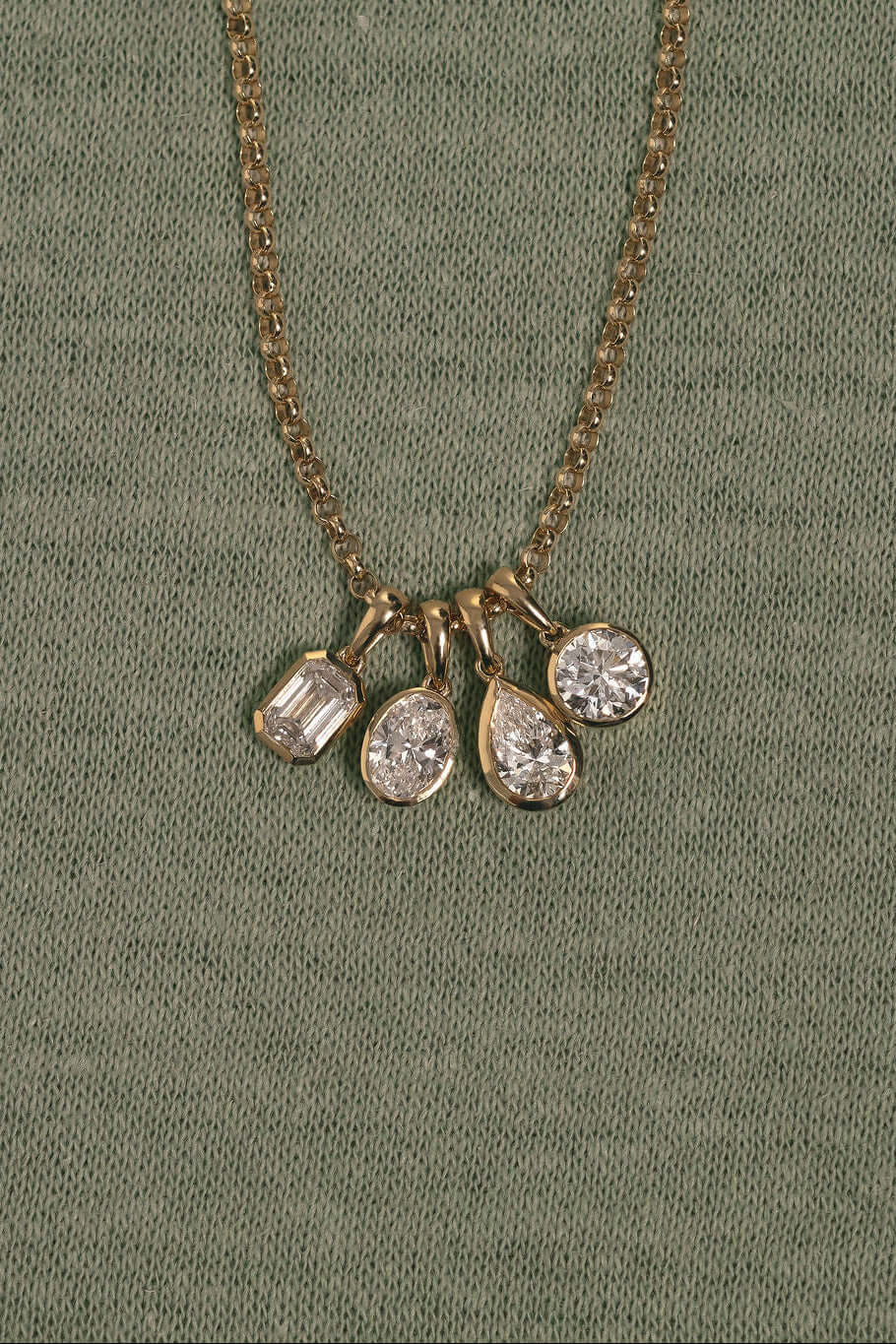 1ct Oval Lab Diamond Bezel Pendant showcasing four diamond charms in yellow gold on a chain.