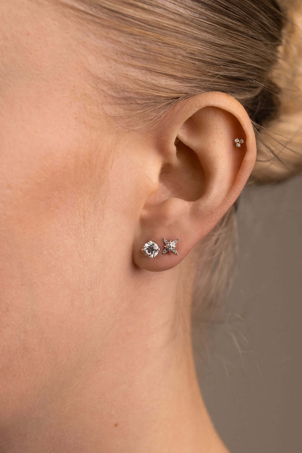 Round Brilliant Stud Earrings Lab Diamond featured in a close-up of a woman's ear with two elegant lab diamond earrings.