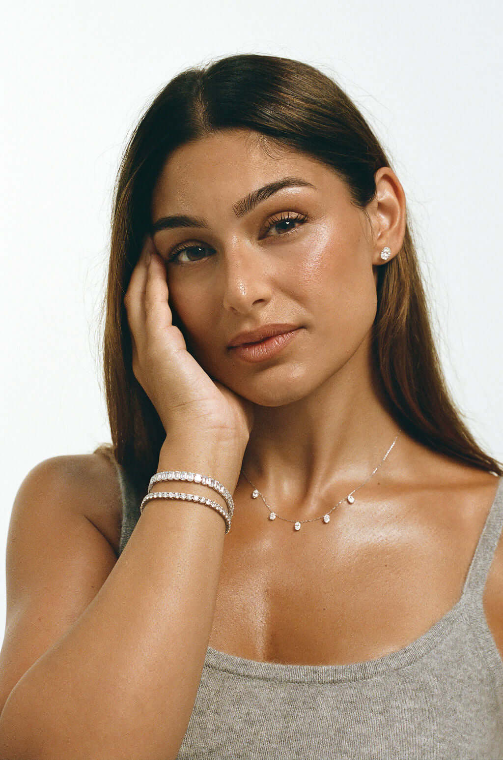 Emerald Bezel Tennis Bracelet 15ct Lab Diamond worn by a model with delicate jewelry against a soft background.